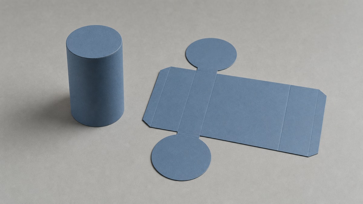Planificação de figuras geométricas espaciais Cilindro de cartão montado ao lado de sua estrutura aberta e planificada com retângulo e duas bases circulares.